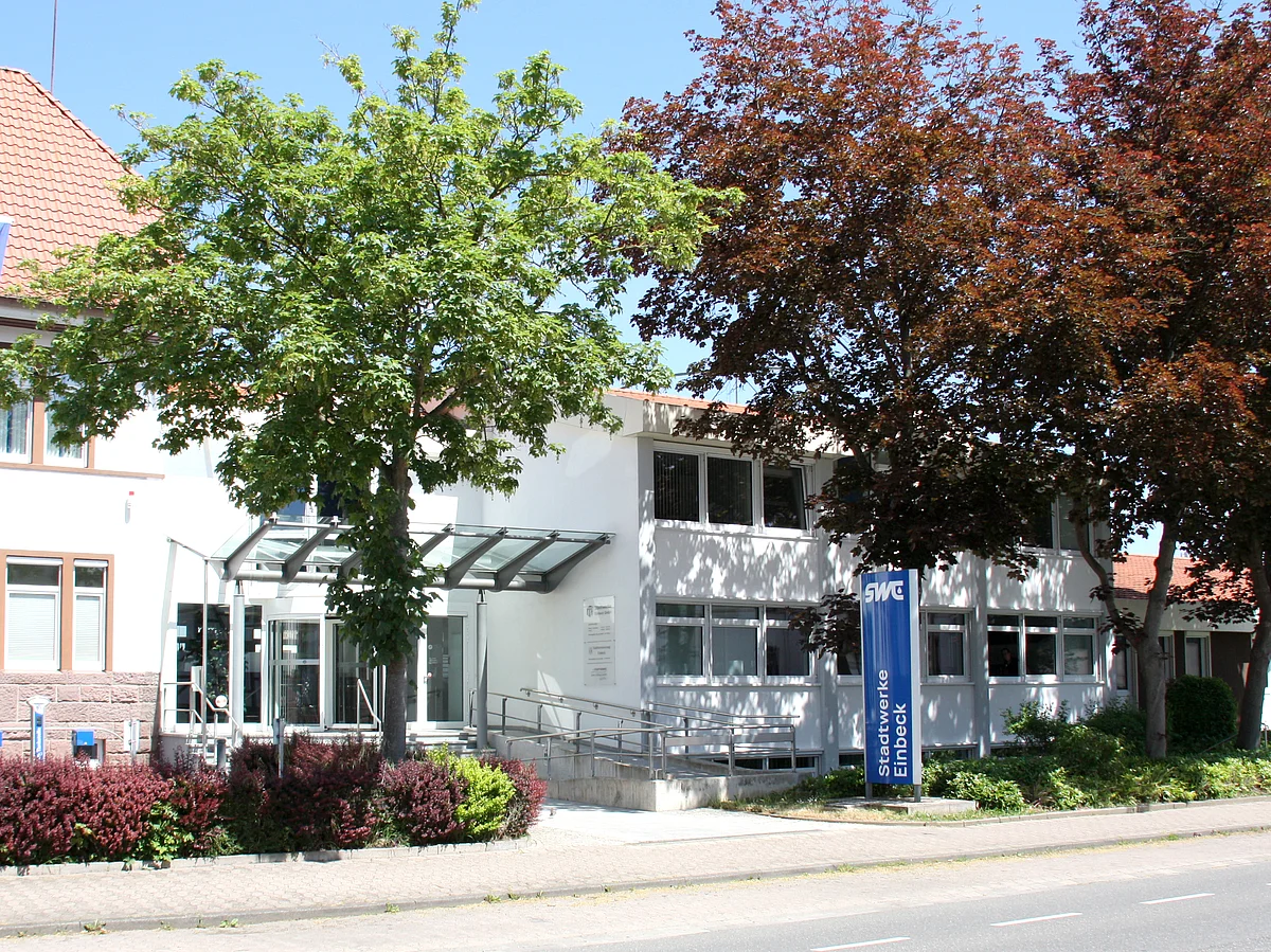 Eingangsbereich der Stadtwerke Einbeck in der Grimsehlstraße 17 mit moderner Überdachung und Glasfront, daneben ist ein Schild mit dem Schriftzug Stadtwerke Einbeck.
